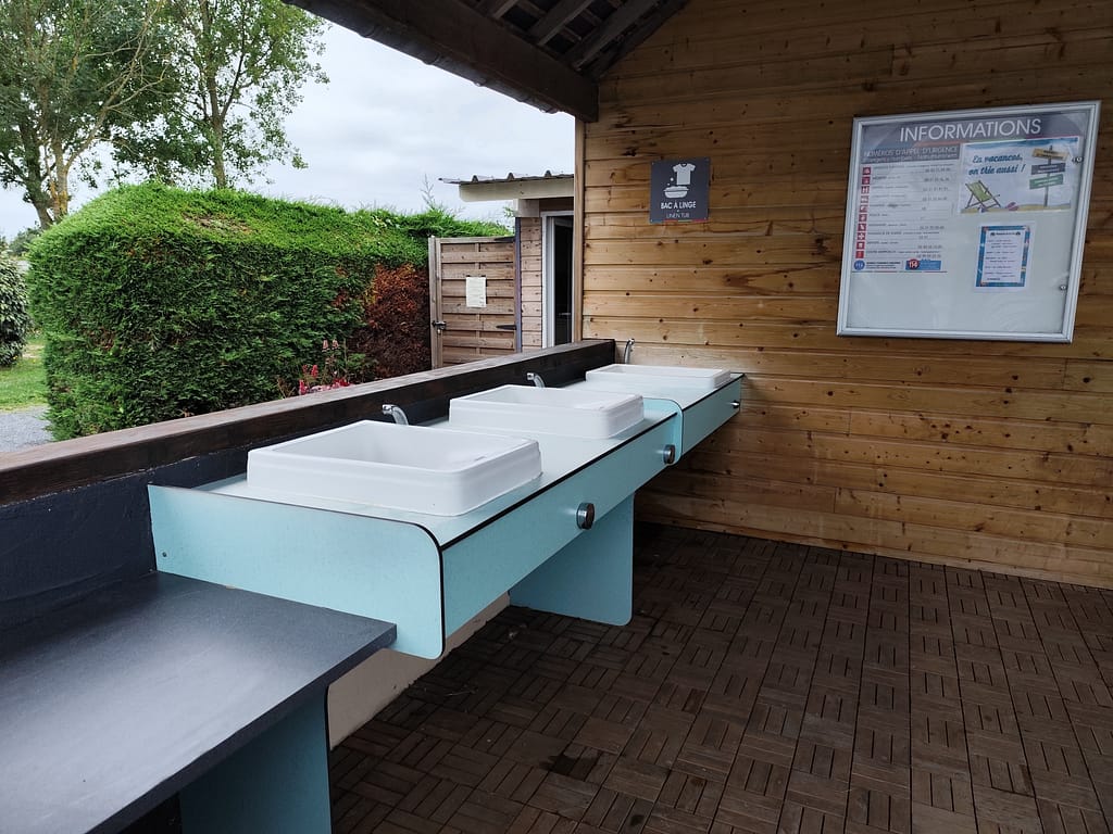 Udendørs, overdækket opvaskeområde med moderne faciliteter på Camping Le Robinson
