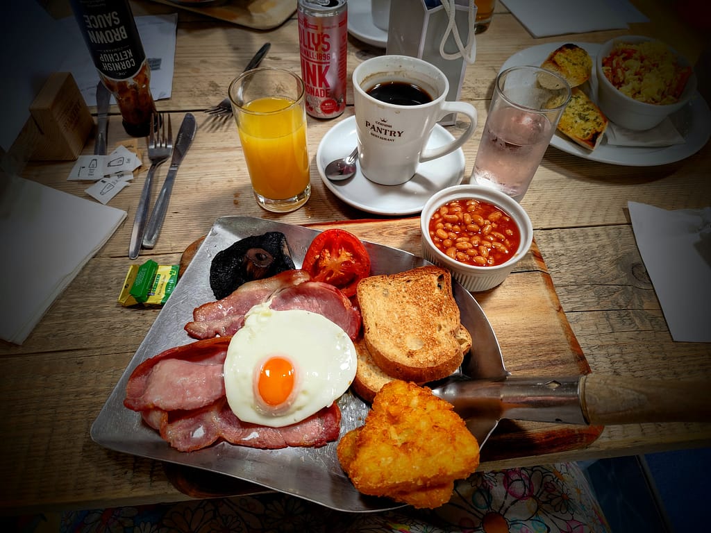 Klassisk engelsk morgenmad med æg, bacon, toast og baked beans hos Cornwall Gold i Cornwall – et godt eksempel på sparetips til campingferien via lokale anbefalinger