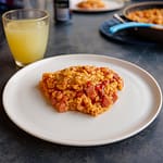 Cajun one-pot med røget pølse serveret på campingbord, lavet i Cadac Paella-pande