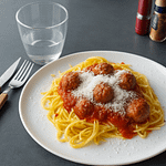 Spaghetti med kødboller serveret som nem campingmad, med krydret tomatsauce og friskrevet parmesan på en tallerken..